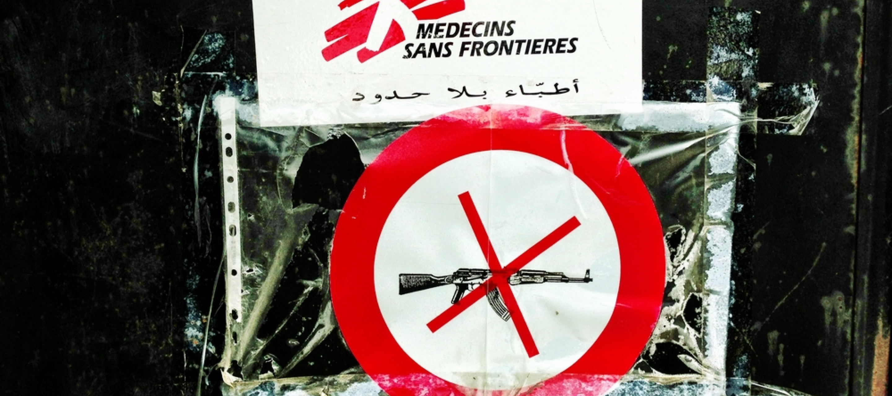 Ein Piktogramm mit einem durchgestrichenen Gewehr und einem Ärzte ohne Grenzen Schild